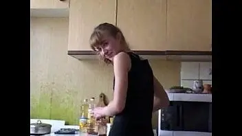 The daughter flirts with her father in the kitchen